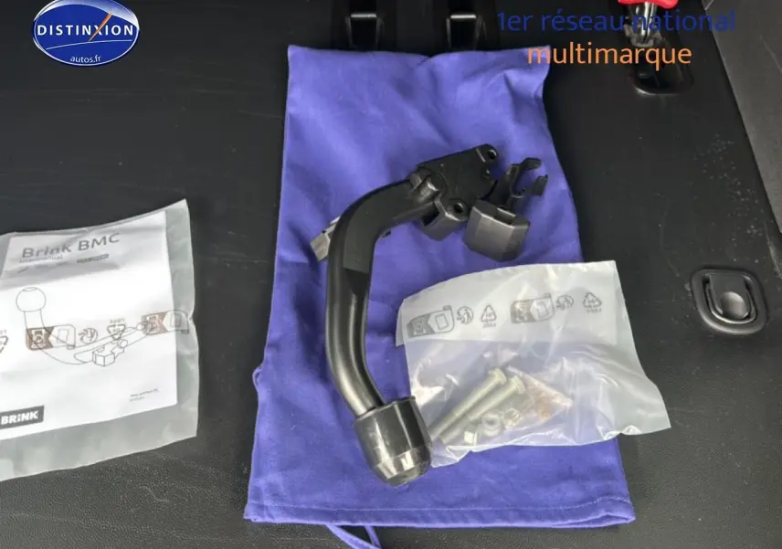 Gros plan sur un attelage col de cygne noir posé sur un tissu bleu dans le coffre d’un FIAT Scudo Combi noir.
