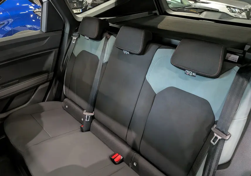 Vue intérieure arrière des sièges arrière noirs et gris du Dacia Bigster Hybrid-G 150 4x4, avec appuie-têtes et ceintures visibles.