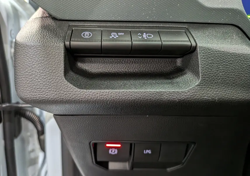 Gros plan sur les commandes intérieures noires du tableau de bord du Dacia Bigster Hybrid-G 150 4x4 blanc Glacier.