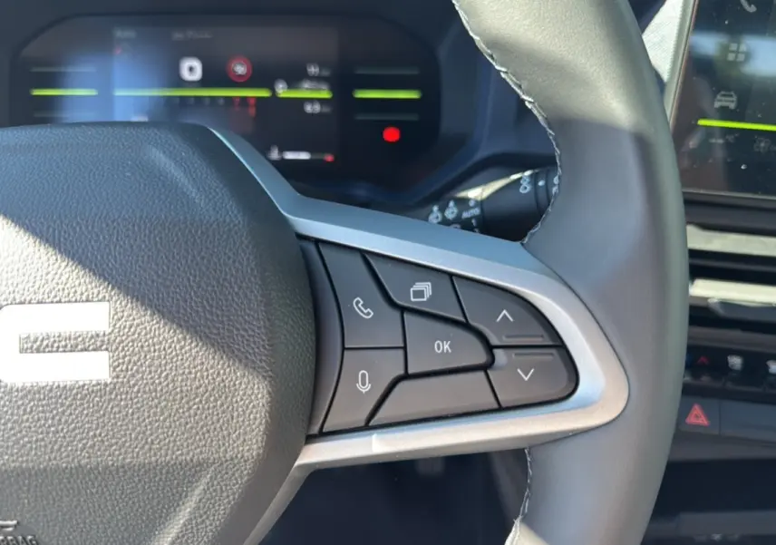 Gros plan sur le volant cuir du Dacia Bigster 2025, mettant en valeur les commandes multifonctions à droite.