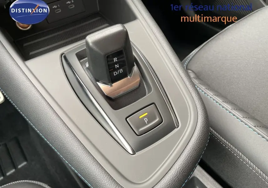 Gros plan sur la console centrale et levier de vitesses automatique du Renault Symbioz gris Rafale métal, avec surpiqûres bleues.
