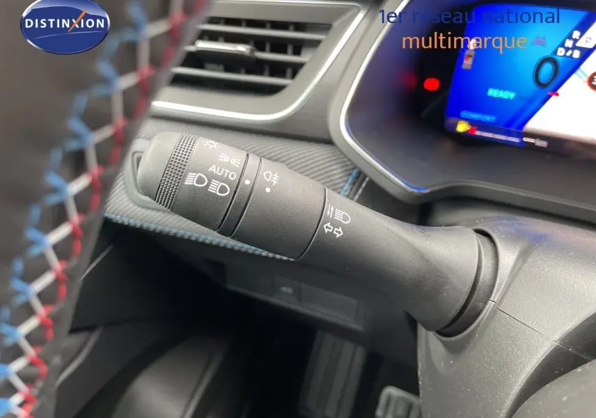 Gros plan sur la commande des feux à gauche du volant dans l’habitacle du Renault Symbioz gris Rafale Métal.