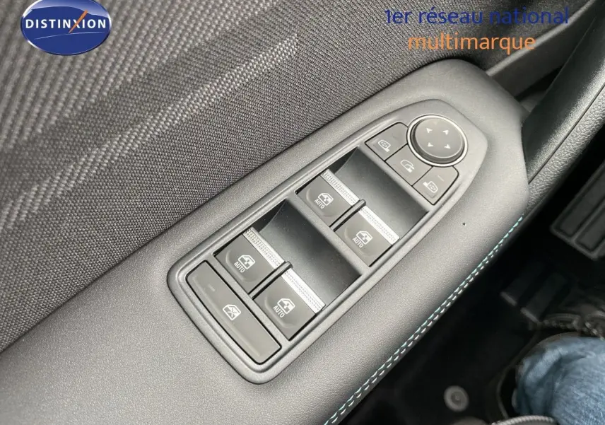 Gros plan sur les commandes des vitres électriques côté conducteur avec surpiqûres bleues, intérieur noir du Renault Symbioz gris Rafale.