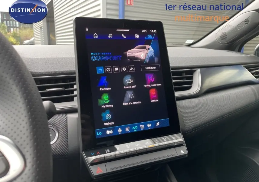 Vue intérieure centrée sur l'écran tactile vertical du tableau de bord du Renault Symbioz gris Rafale Metal, avec volant partiel à gauche.