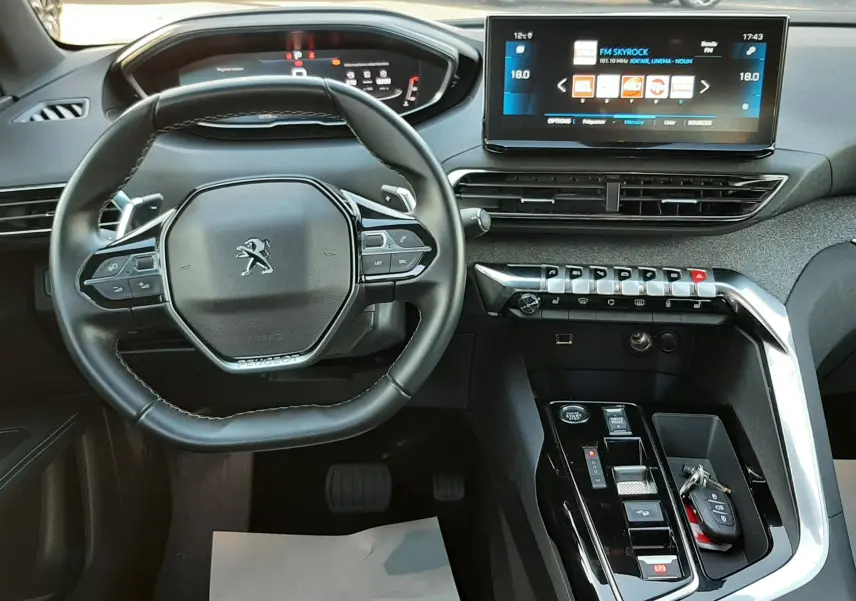 Vue intérieure du poste de conduite du Peugeot 3008 gris platinium 2023, avec volant multifonction et écran tactile central.