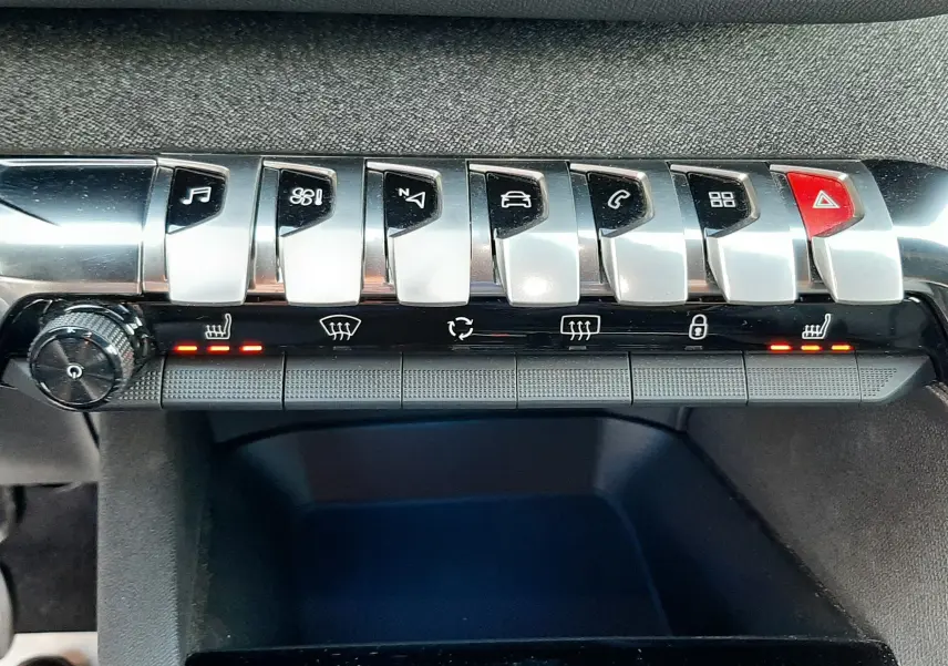 Gros plan sur la console centrale du Peugeot 3008 gris platinium 2023, montrant les boutons de commande et le bouton start/stop.