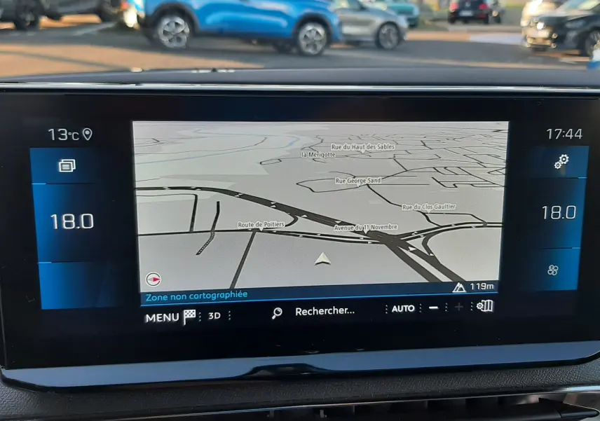 Écran central du tableau de bord du Peugeot 3008 gris platinium 2023 affichant la navigation GPS et la température intérieure à 18°C.