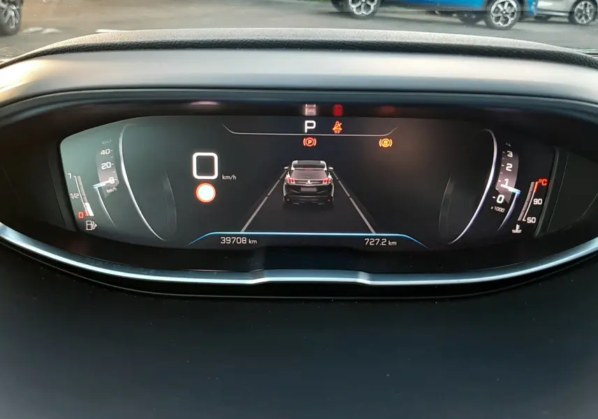 Vue du tableau de bord numérique du Peugeot 3008 gris platinium 2023, affichant la vitesse à 0 km/h et l'alerte de stationnement.