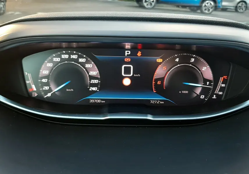 Tableau de bord numérique du Peugeot 3008 2023, affichant vitesse à 0 km/h et compteurs modernes en vue frontale.