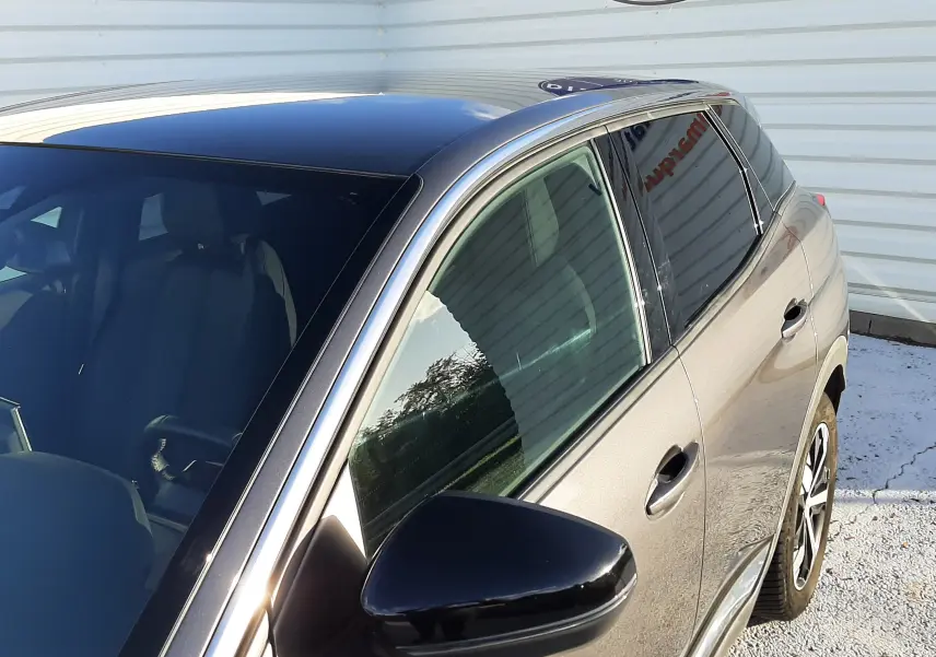 Vue 3/4 avant droit du Peugeot 3008 gris platinium 2023 avec toit noir et rétroviseur noir brillant.