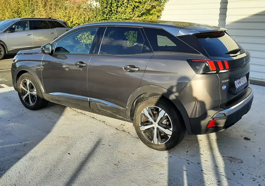 Peugeot 3008 gris platinium vue 3/4 arrière côté gauche, avec jantes alliage et feux arrière distinctifs à LED.