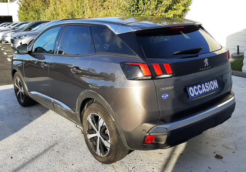 Vue 3/4 arrière droite d’un Peugeot 3008 gris platinium 2023 avec feux arrière à LED et jantes alliage bicolores.