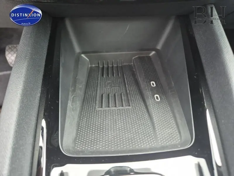 Gros plan sur le chargeur sans fil noir intégré à la console centrale de la Skoda Octavia Combi 2024.