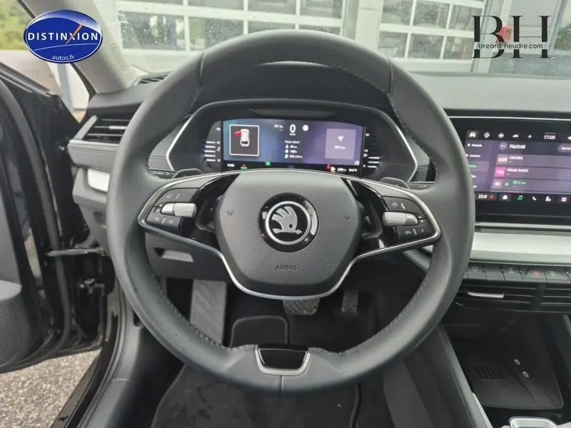 Vue centrée sur le volant cuir multifonction d'une Skoda Octavia Combi 2024, tableau de bord numérique visible.
