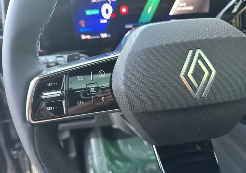 Gros plan sur le volant du Renault Austral New 200 Esprit Alpine 2025 avec commandes intégrées et logo central chromé.