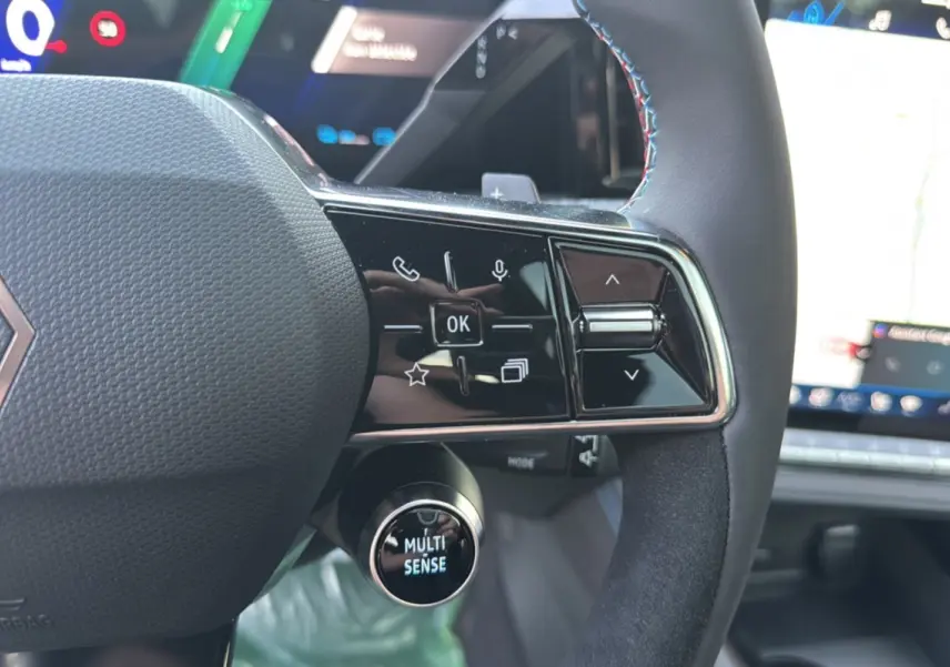 Gros plan sur le volant du Renault Austral New 200 Esprit Alpine, noir étoilé, avec commandes multifonctions et bouton Multi-Sense.
