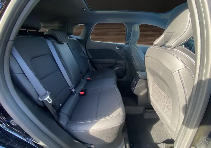 Vue intérieure côté droit sur la banquette arrière noire étoile du Renault Symbioz Iconic E-Tech Hybrid 2025 avec toit panoramique.