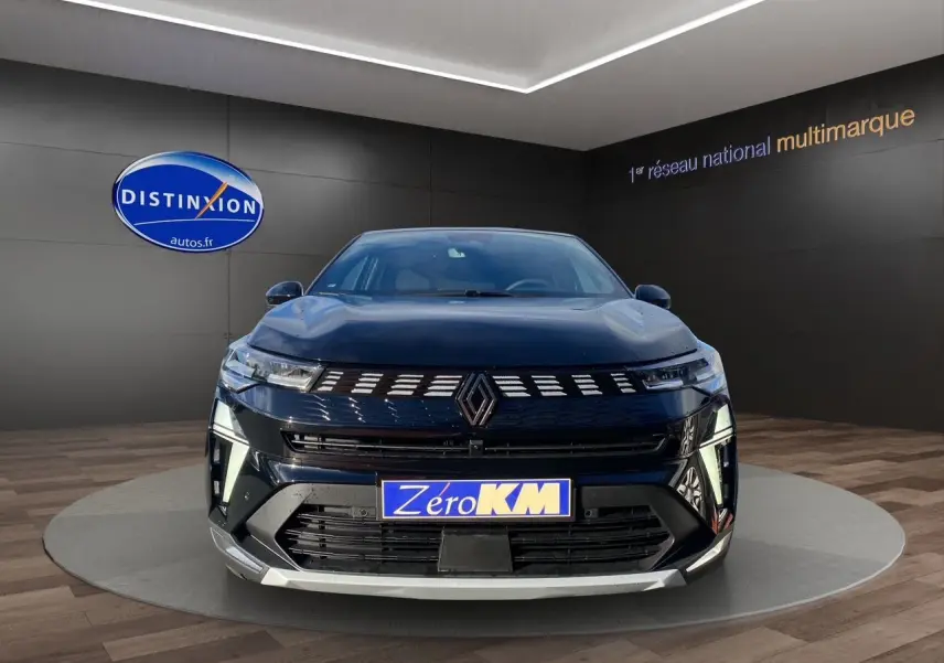 Vue de face d'une Renault Symbioz noire étoile avec calandre lumineuse et plaque Zéro KM dans un showroom.