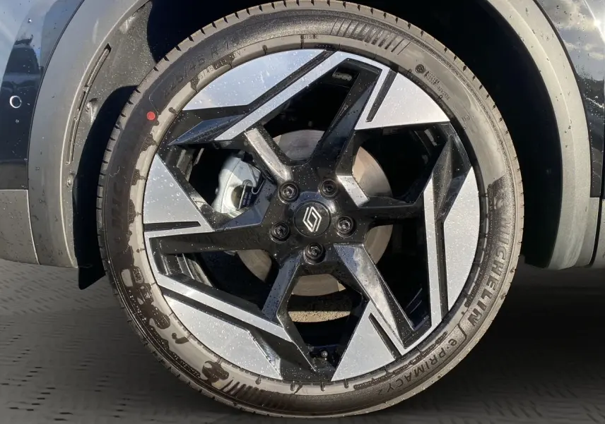 Gros plan sur la jante alliage bicolore noire et argentée du Renault Symbioz noir étoile, avec logo central Renault.