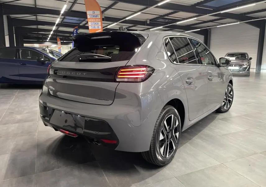 Vue 3/4 arrière droite d'une Peugeot 208 hybride gris sélénium avec feux arrière à LED et jantes alliage diamantées.