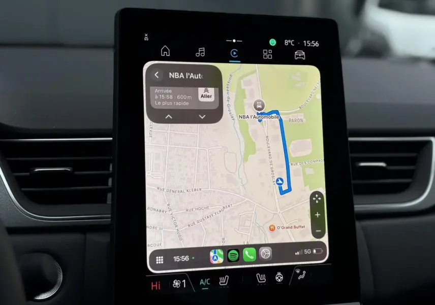Écran tactile central du tableau de bord du Renault Captur 2025 affichant la navigation GPS et commandes climatisation.