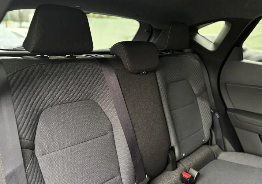 Vue intérieure sur la banquette arrière grise du Renault Captur 2025, avec ceintures de sécurité et appuie-têtes visibles.