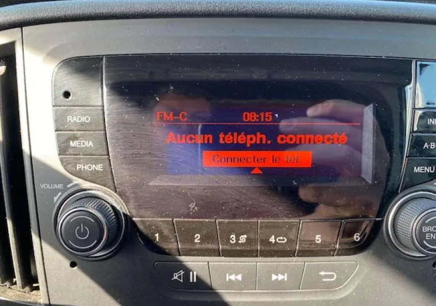 Gros plan sur l’autoradio du Fiat Doblo 2017 affichant l’écran rouge indiquant "Aucun téléph. connecté".