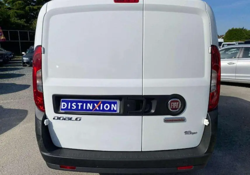 Vue arrière d’un FIAT Doblo blanc de 2017 avec portes tôlées et pare-chocs noirs non peints.