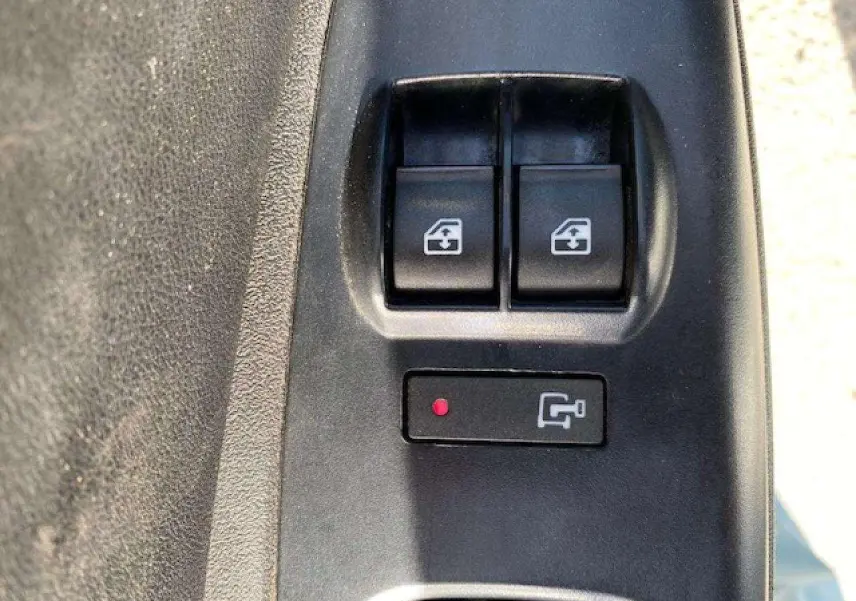 Gros plan sur les commandes de lève-vitres électriques côté conducteur du Fiat Doblo blanc de 2017.