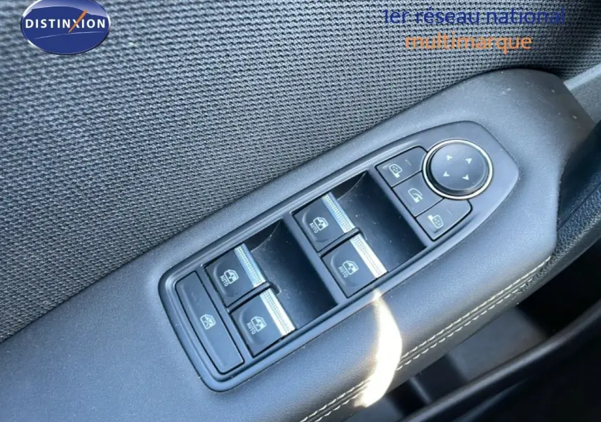 Gros plan sur les commandes électriques des vitres côté conducteur d’une Renault Symbioz noire étoile métal, intérieur tissu noir.