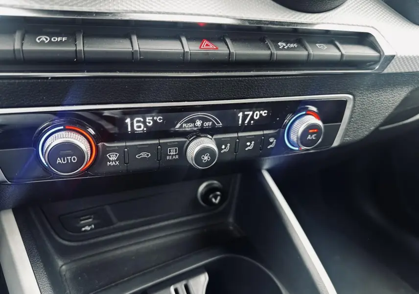 Vue rapprochée de la console centrale de l’Audi Q2 2017, montrant la climatisation automatique et les commandes de température.