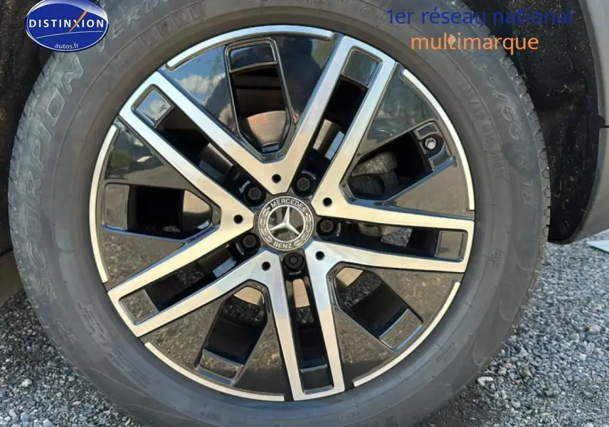 Gros plan sur la jante alu noire et argentée d'un Mercedes GLA 200 gris, vue de face sur le pneu.