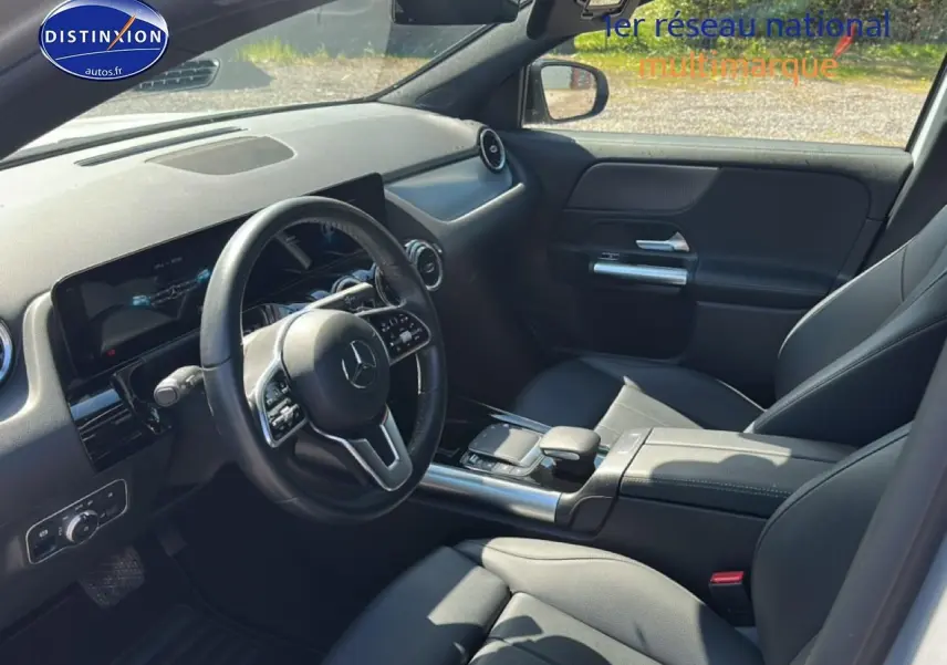 Intérieur noir de la Mercedes GLA 200 2022 vu côté conducteur, avec volant cuir multifonction et console centrale moderne.
