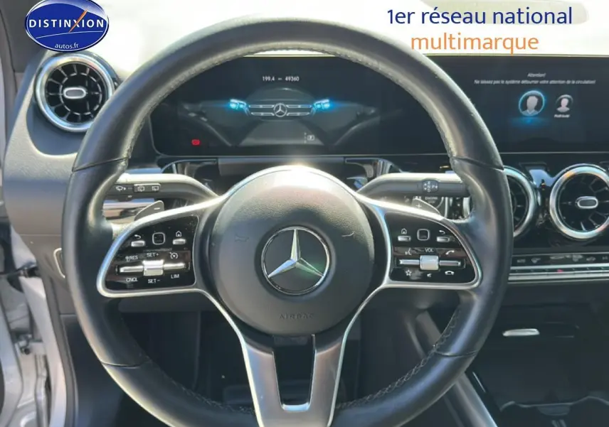 Vue rapprochée du volant cuir multifonction noir de la Mercedes GLA 200 2022 avec tableau de bord numérique.