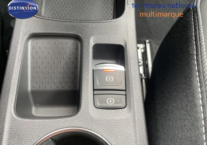 Gros plan sur la console centrale noire avec commandes de frein à main électronique et rangement du Renault Symbioz gris cassiopée.