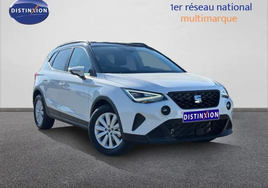 SEAT Arona blanc Candy avec toit noir, vue 3/4 avant droit, jantes alu et calandre noire distinctive.