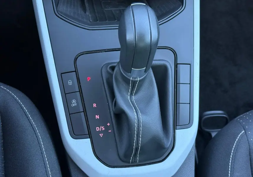 Gros plan sur le levier de vitesse automatique en cuir noir avec surpiqûres blanches dans une SEAT Arona 2025.