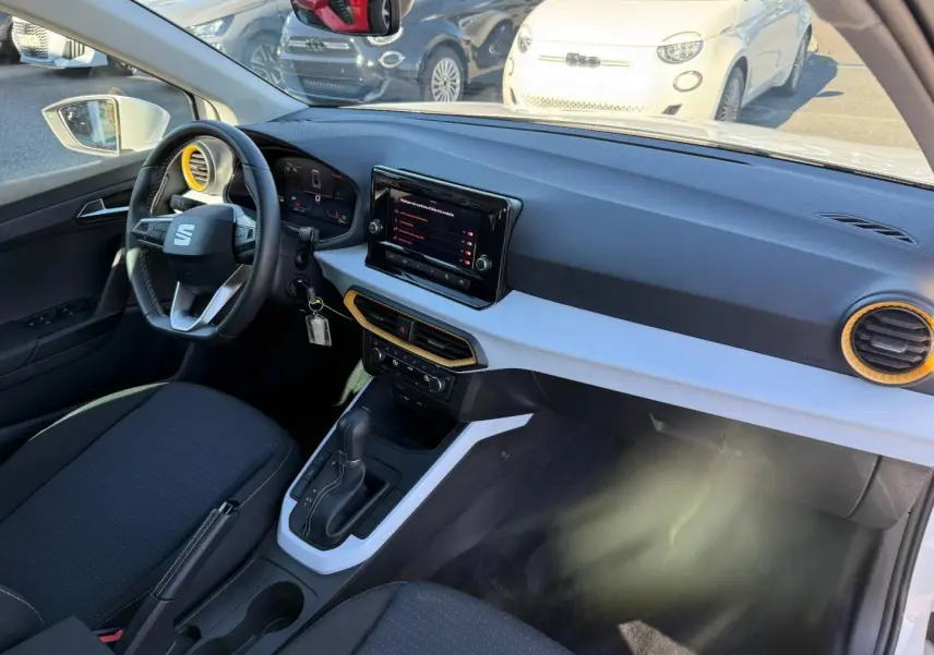Intérieur avant droit du SEAT Arona blanc, volant cuir multifonction et tableau de bord avec écran tactile.