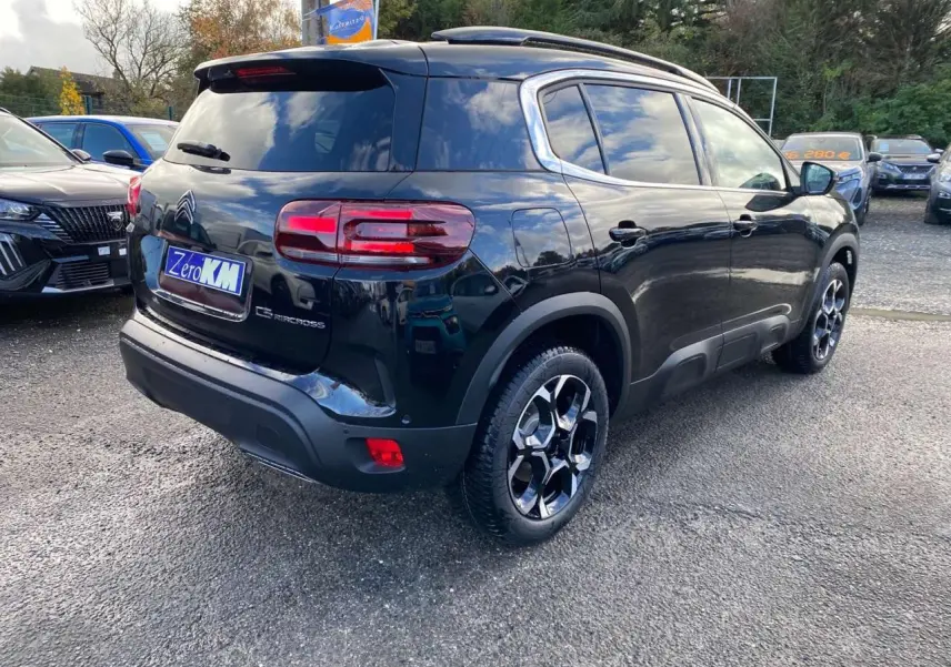 Vue 3/4 arrière droite d'un SUV Citroën C5 Aircross noir perla avec jantes alliage bi-ton et vitres surteintées.