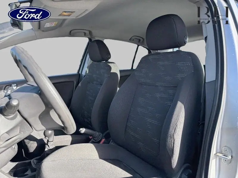 Vue intérieure côté conducteur de l'Opel Corsa gris minéral 2014, sièges tissu anthracite et volant réglable.