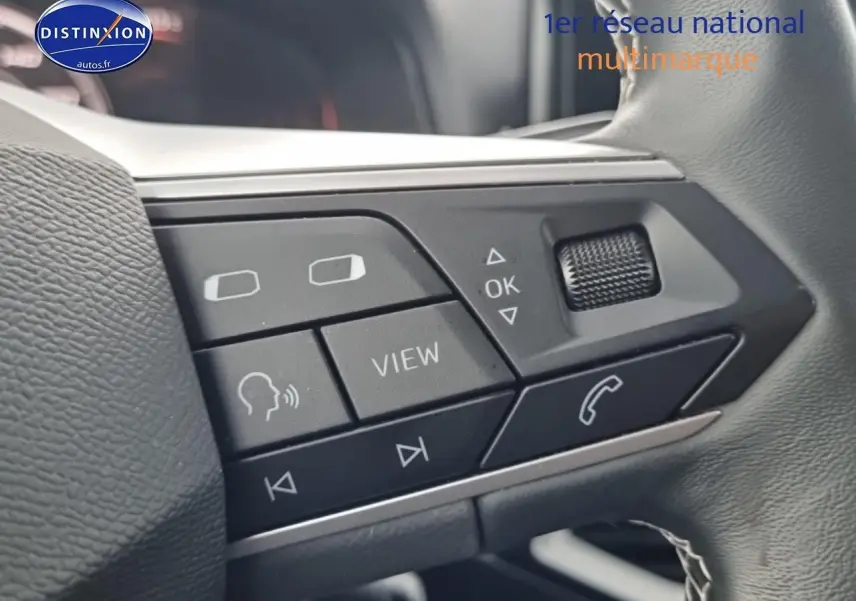 Gros plan sur les commandes multifonctions noires du volant cuir du SEAT Arona gris magnétique 2025.