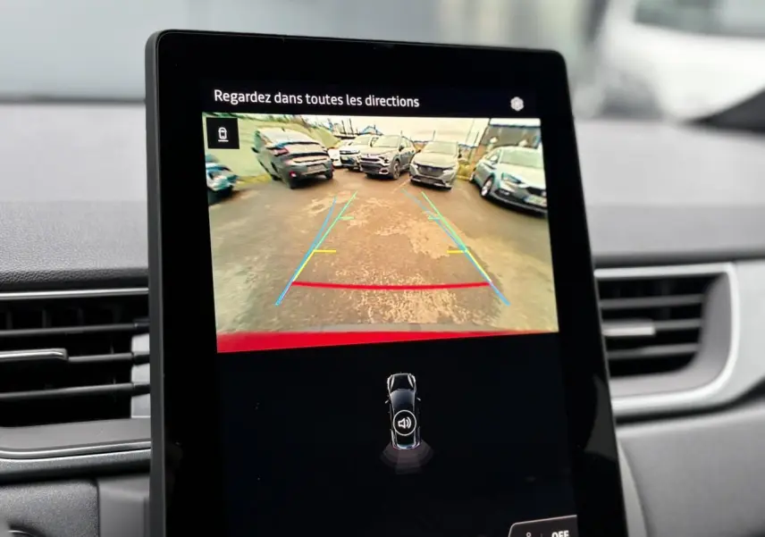 Écran central du Renault Captur 2025 affichant la caméra de recul avec lignes de guidage, intérieur gris.