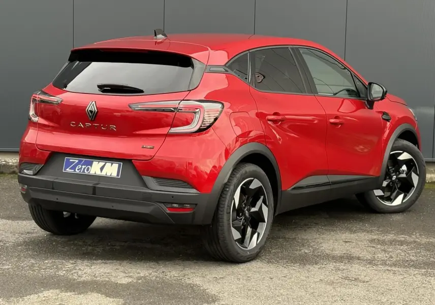 Vue 3/4 arrière droite du Renault Captur Rouge Flamme avec jantes aluminium noires et vitres surteintées.