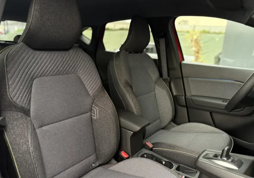 Vue intérieure côté gauche des sièges avant gris anthracite du Renault Captur 2025 avec console centrale et levier de vitesses.