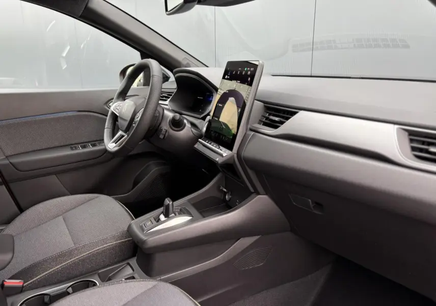 Vue intérieure côté conducteur du Renault Captur 2025 avec tableau de bord moderne et écran tactile vertical.