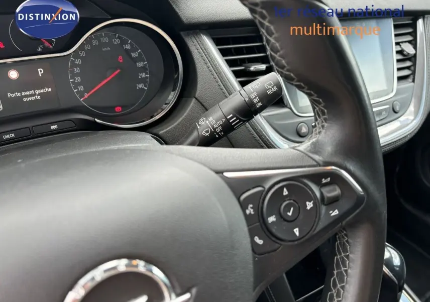 Gros plan sur le volant en cuir noir et le tableau de bord digital d’un Opel Grandland X 2019, intérieur moderne.