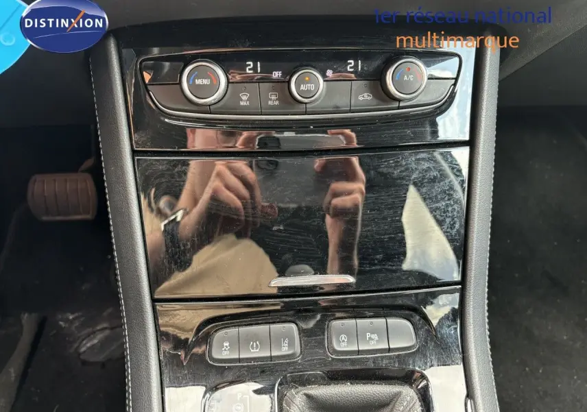 Vue rapprochée du tableau de bord noir brillant de l’Opel Grandland X 2019 avec commandes de climatisation et boutons fonctionnels.