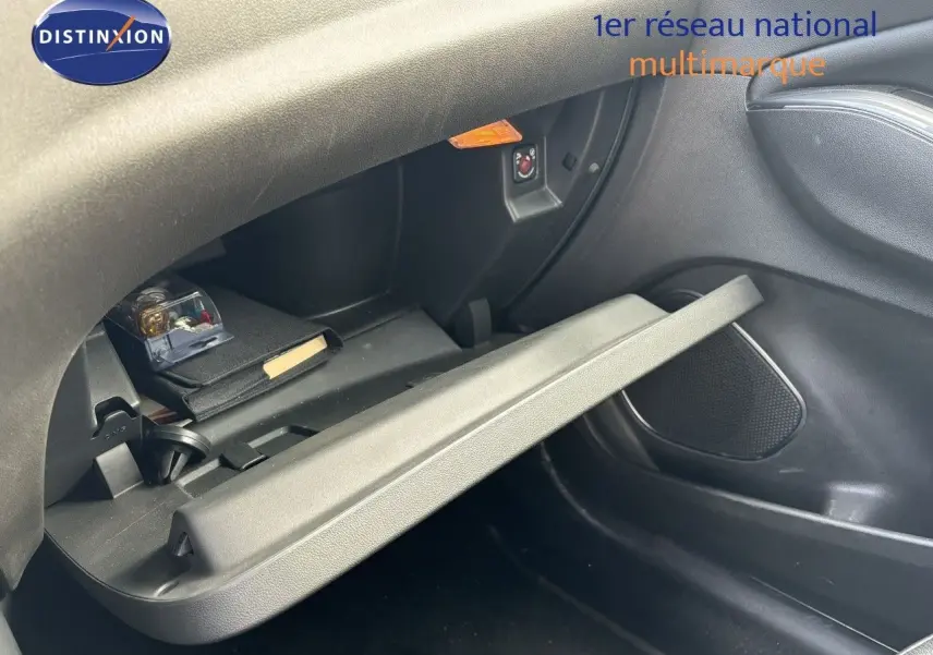 Gros plan sur la boîte à gants ouverte côté passager de l’Opel Grandland X noir, montrant son intérieur et un rangement.