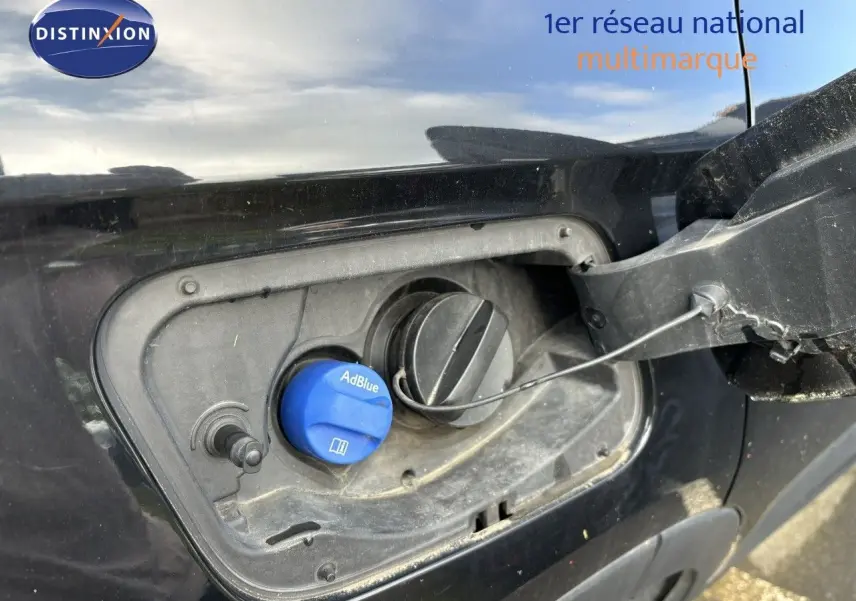 Gros plan sur la trappe à carburant côté gauche d’un Opel Grandland X noir avec bouchon AdBlue visible.