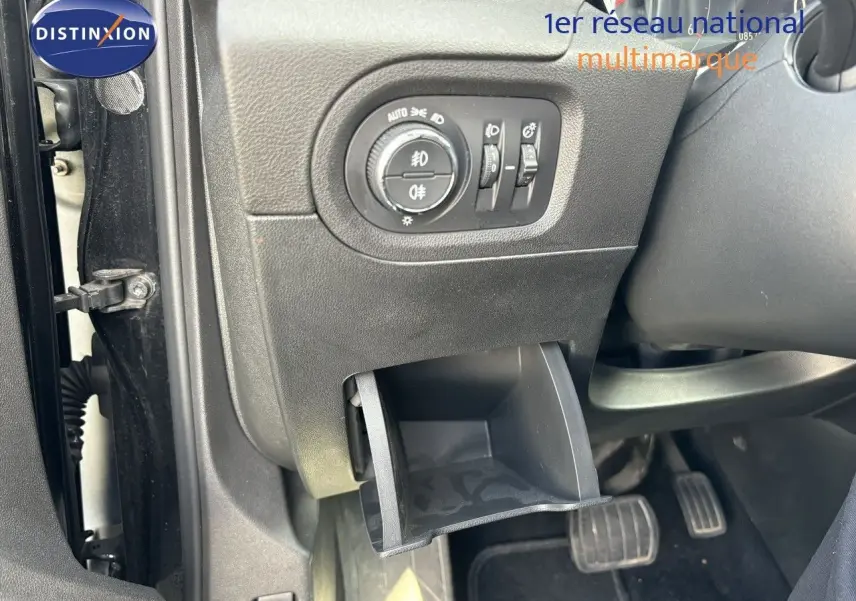 Détail intérieur côté gauche d'un Opel Grandland X noir 2019, montrant les commandes d'éclairage et un petit rangement ouvert.